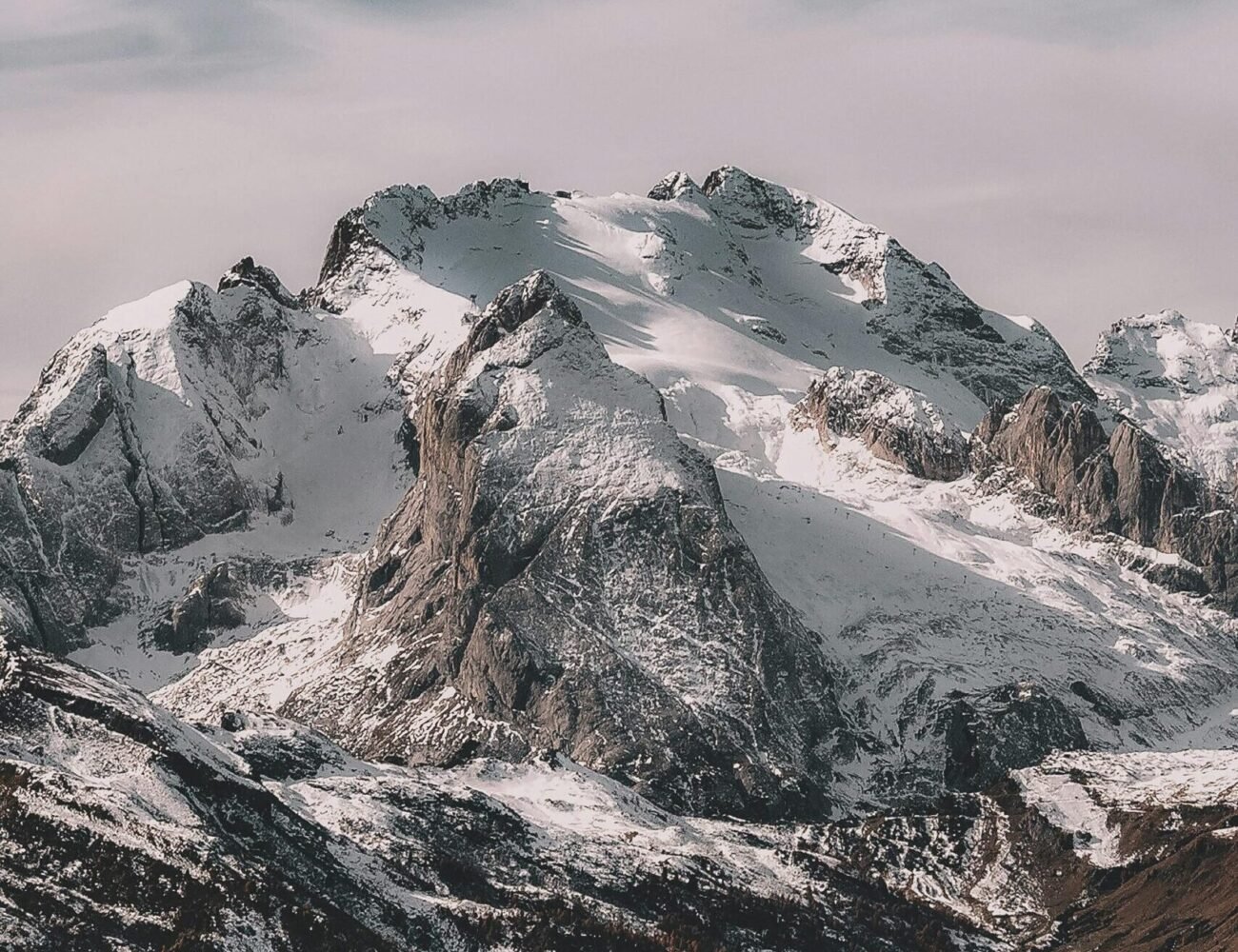 A breathtaking view of a snow-capped mountain range under a clear sky, capturing winter's beauty.